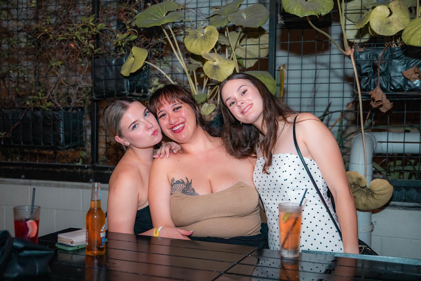 Three friends leaning in together for a photograph